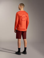 Oranges A-Dura Air Langarmtrikot mit Rückengrafik und bordeauxrote A-Dura Ride Shorts, Performance-MTB-Ausrüstung.