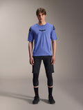 Alpinestars A-Aria Lite Short, Herren-Mountainbike-Shorts, Schwarz, getragen mit hellviolettem Kurzarm-Trikot und schwarzen Knieschonern, Performance-MTB-Bekleidung