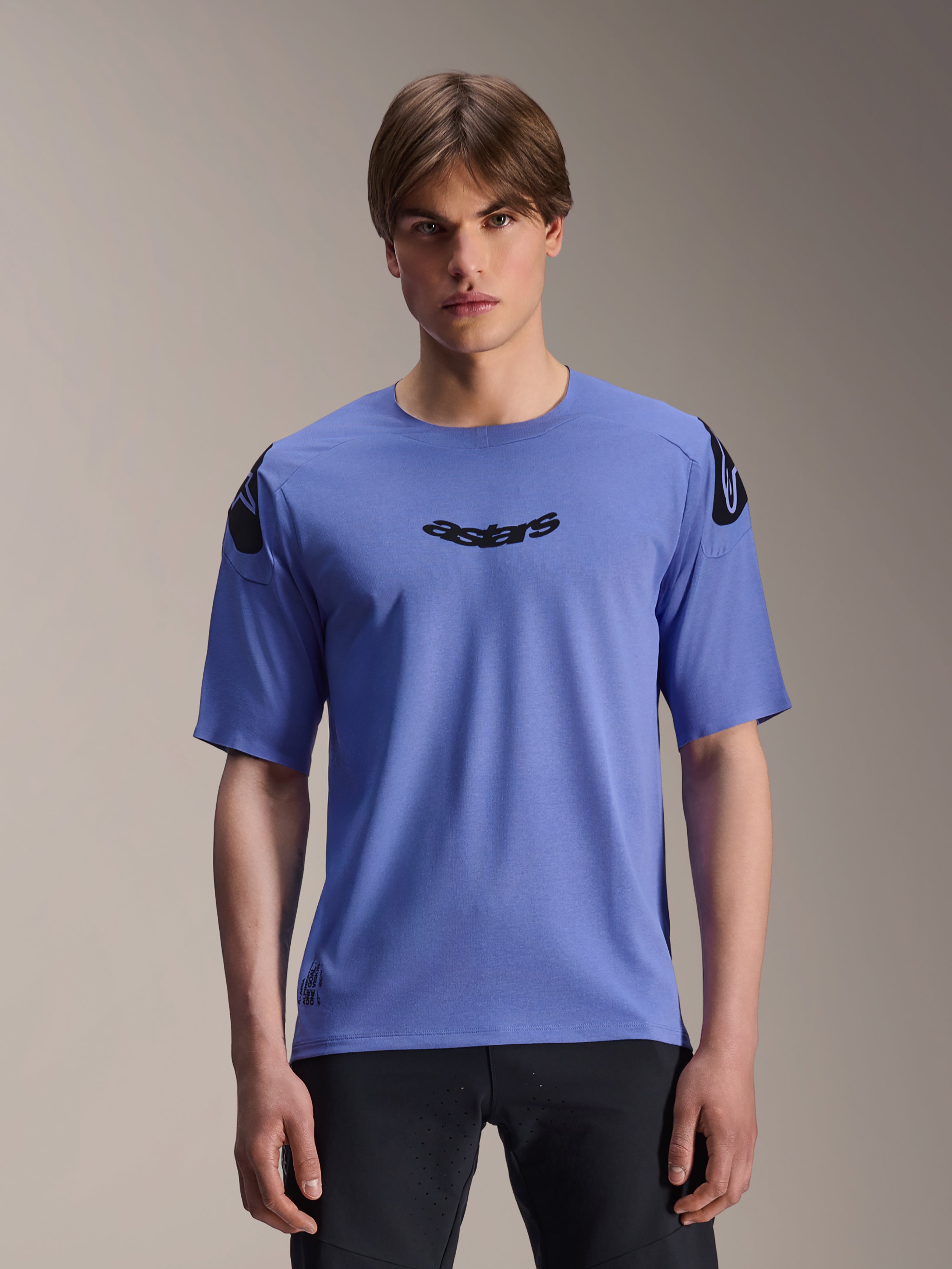 Alpinestars A-Aria Polartec Elite Trikot, Kurzarm-MTB-Trikot, Baja Blue, getragen von einem männlichen Model, mit schwarzem 'astars' Schriftzug auf der Brust und Logo-Details an den Schultern, Performance-Trail-Bekleidung.