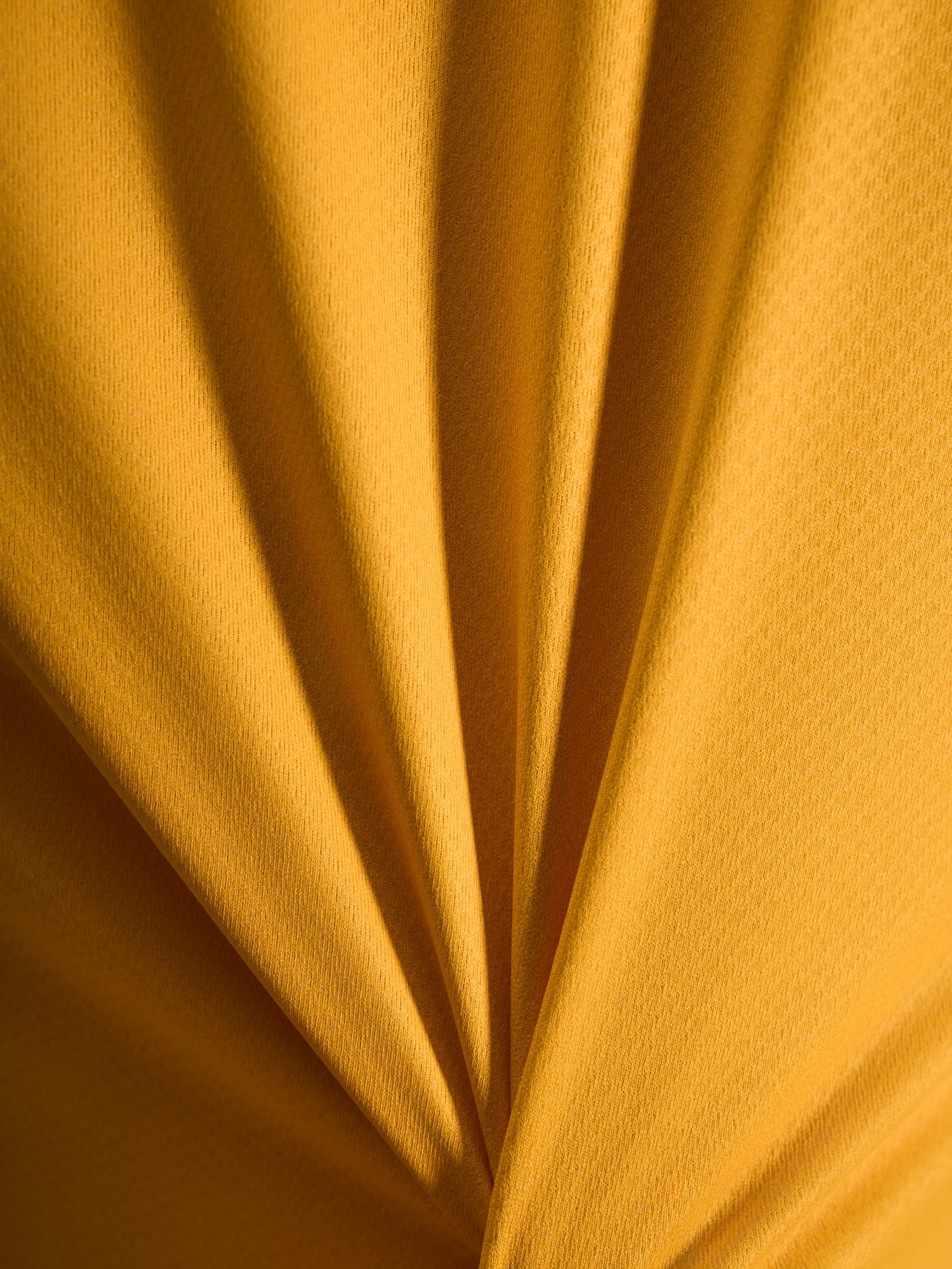 Orangefarbene Textur des A-Dura Ride Trikots aus leichtem Jacquard-Poly-Spandex-Material in der Detailansicht.