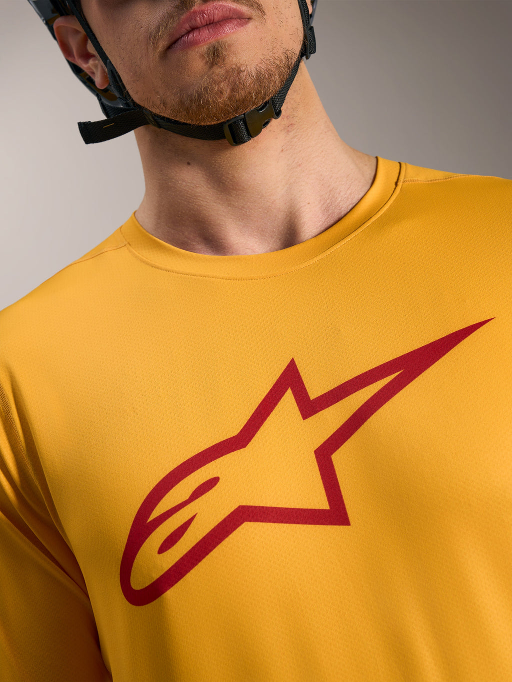 Oranges A-Dura Ride Kurzarmtrikot mit rotem Astars-Logo auf der Brust, leichte MTB-Performance-Bekleidung.