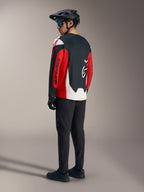 Rotes A-Dura Race Langarmtrikot mit Alpinestars-Grafiken, Rückansicht in einem Mountainbike-Outfit.