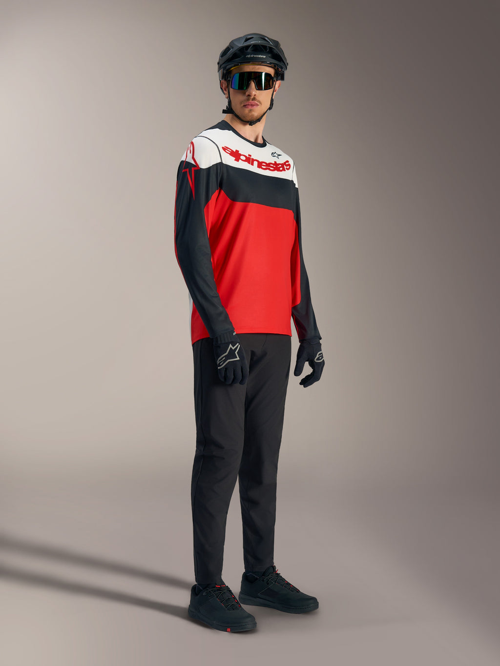 A-Dura Race Langarmtrikot in Rot, Schwarz und Weiß mit Logos und professioneller Mountainbike-Ausrüstung.