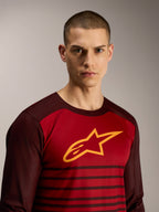 A-Dura Elite Langarmtrikot in Bordeaux mit gelbem Stern-Logo und Streifenmuster für MTB-Performance.