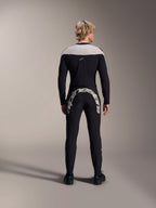 Alpinestars A-Supra Melt Pants, Black, back view showing the large white Alpinestars wordmark across the back yoke, paired with a matching long-sleeve jersey and black riding shoes, high-performance mountain bike gear for off-road riding.