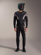 Schwarzes A-Supra Elite MTB-Kit, Langarmtrikot und Rennhose mit grauen Logos, Full-Face-Helm, Profi-Rennbekleidung