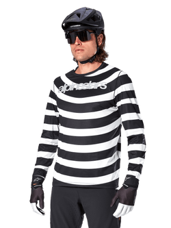 Alpinestars A-Aria Oscar Long Sleeve Jersey, MTB cycling jersey, Black and white horizontal stripes, worn with a black helmet and sunglasses, featuring Alpinestars branding on the chest, performance mountain bike apparel