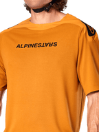 Alpinestars A-Aria Polartec Switch Jersey, Short Sleeve MTB Jersey, Dark Gold, featuring mirrored black Alpinestars logo on the chest, technical performance fabric for mountain bike trail riding