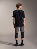 Alpinestars A-Dura Elite Shorts, Dark Gray mountain bike shorts, back view, worn with a black short-sleeve jersey, knee pads, and black socks, technical cycling gear for off-road riding