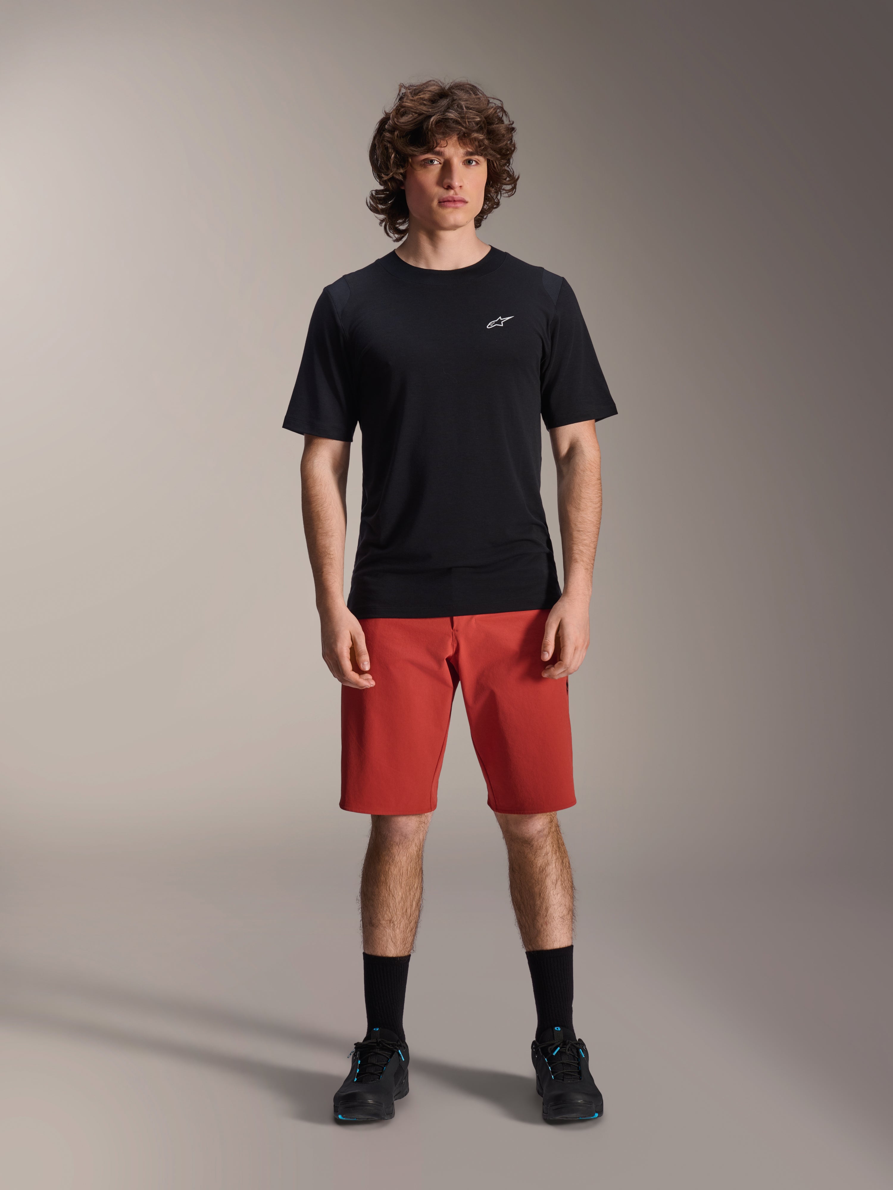 Alpinestars A-Dura Elite Shorts, MTB Mountain Biking Shorts, Dark Orange, worn with a black short-sleeved jersey and cycling shoes, performance cycling apparel for mountain biking
