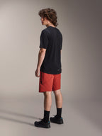 Alpinestars A-Dura Elite Shorts, Mountain Bike Shorts, Dark Orange, worn with a black short-sleeve jersey and black mountain bike shoes, rear side view of model highlighting performance fit and branding