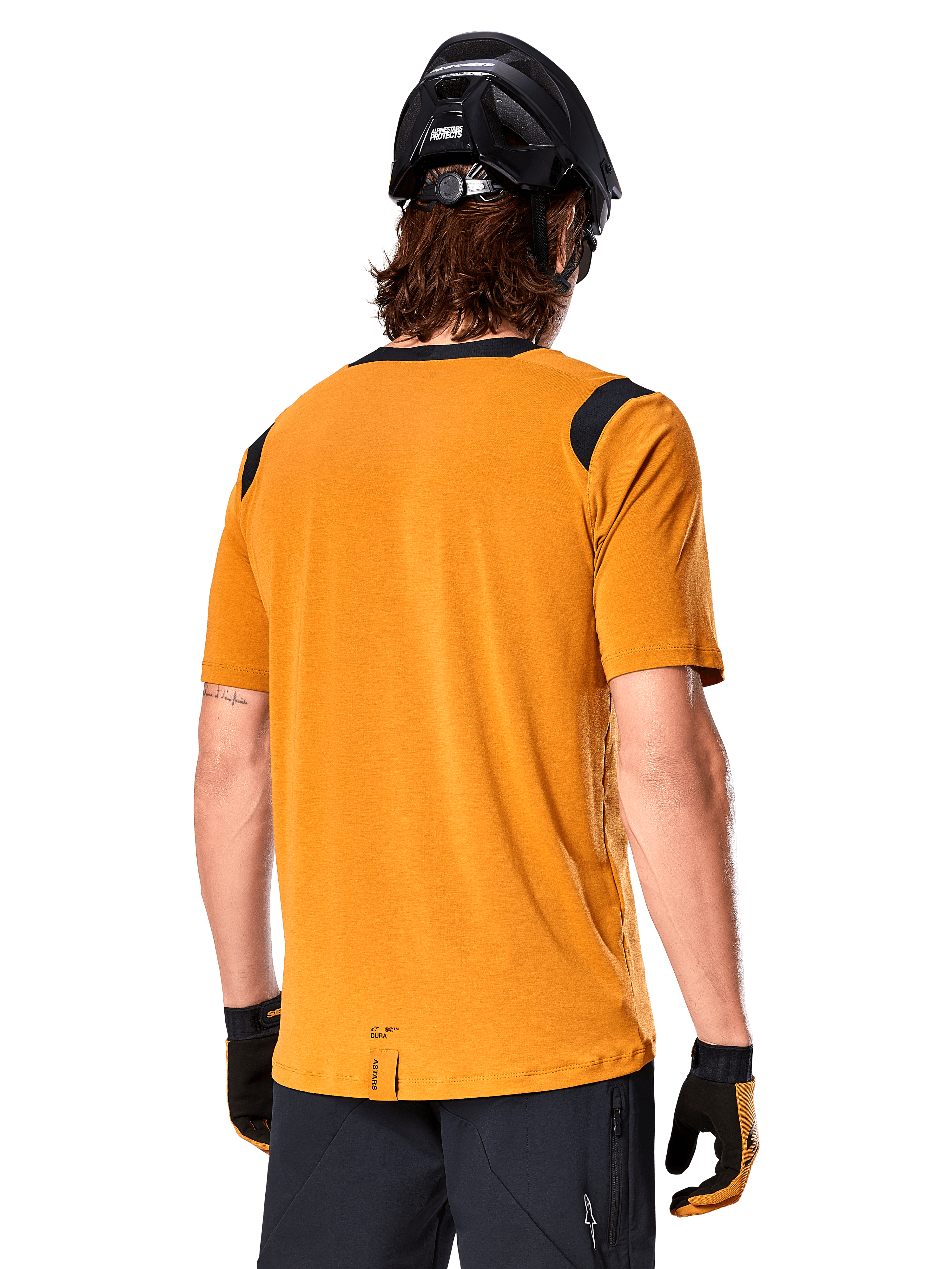 Alpinestars A-Dura Dri Wool Short Sleeve Jersey, Dark Gold, Rear view of a man wearing the short-sleeve jersey with black mesh panels on the shoulders, paired with a black MTB helmet and gloves, regular fit mountain bike gear.