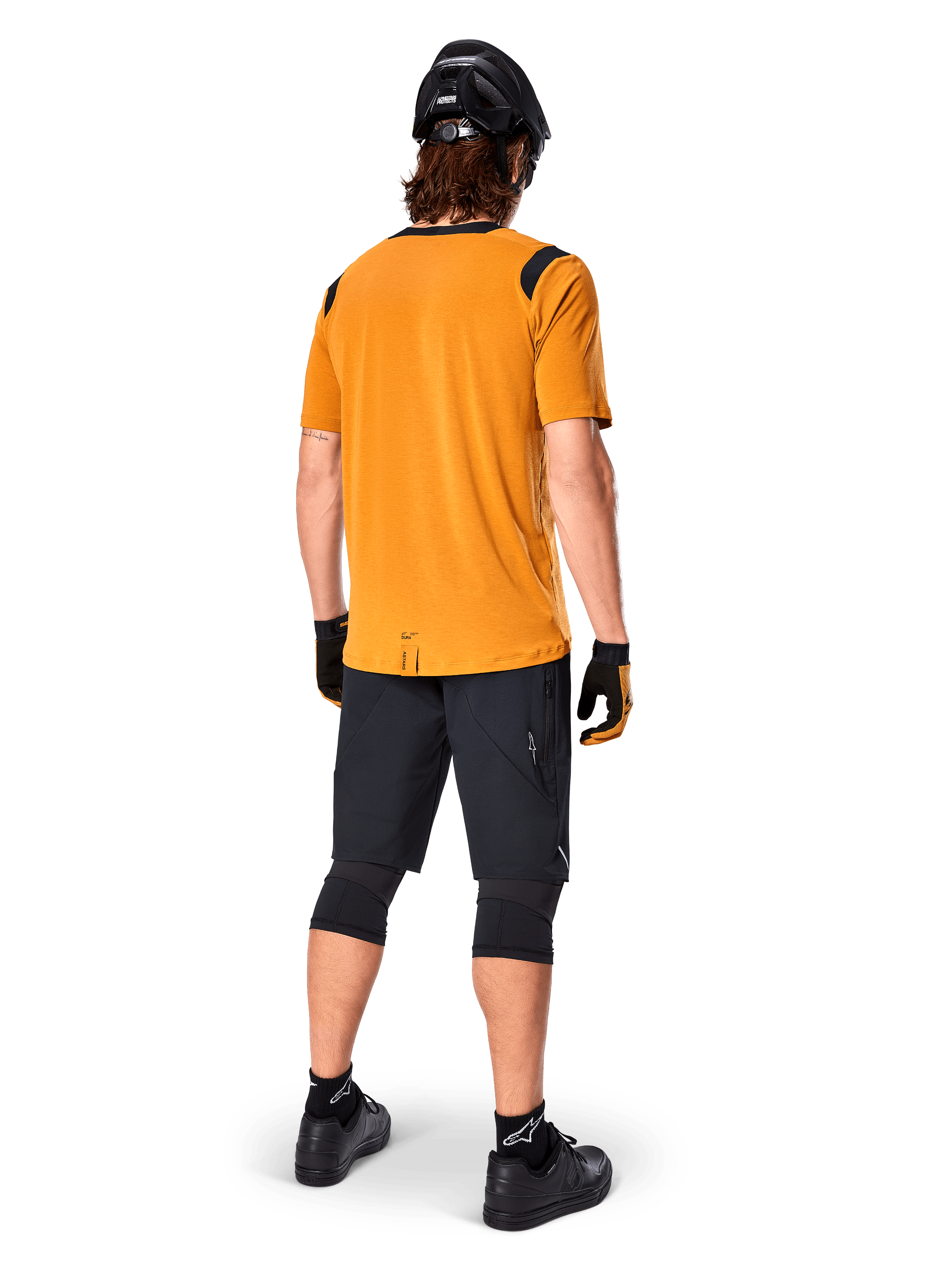 Alpinestars A-Dura Dri Wool Short Sleeve Jersey, Cycling Jersey, Dark Gold, back view of mountain biker wearing mustard-yellow jersey with black mesh shoulder accents, paired with black shorts, knee guards, black helmet, and gloves, technical off-road cycling gear