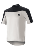 Alpinestars Drop Meta Jersey Short Sleeve, Mountain Biking Jersey, Light Gray and Black, featuring a breathable mesh construction, black shoulder yoke, round neckline, and extended rear tail for coverage.