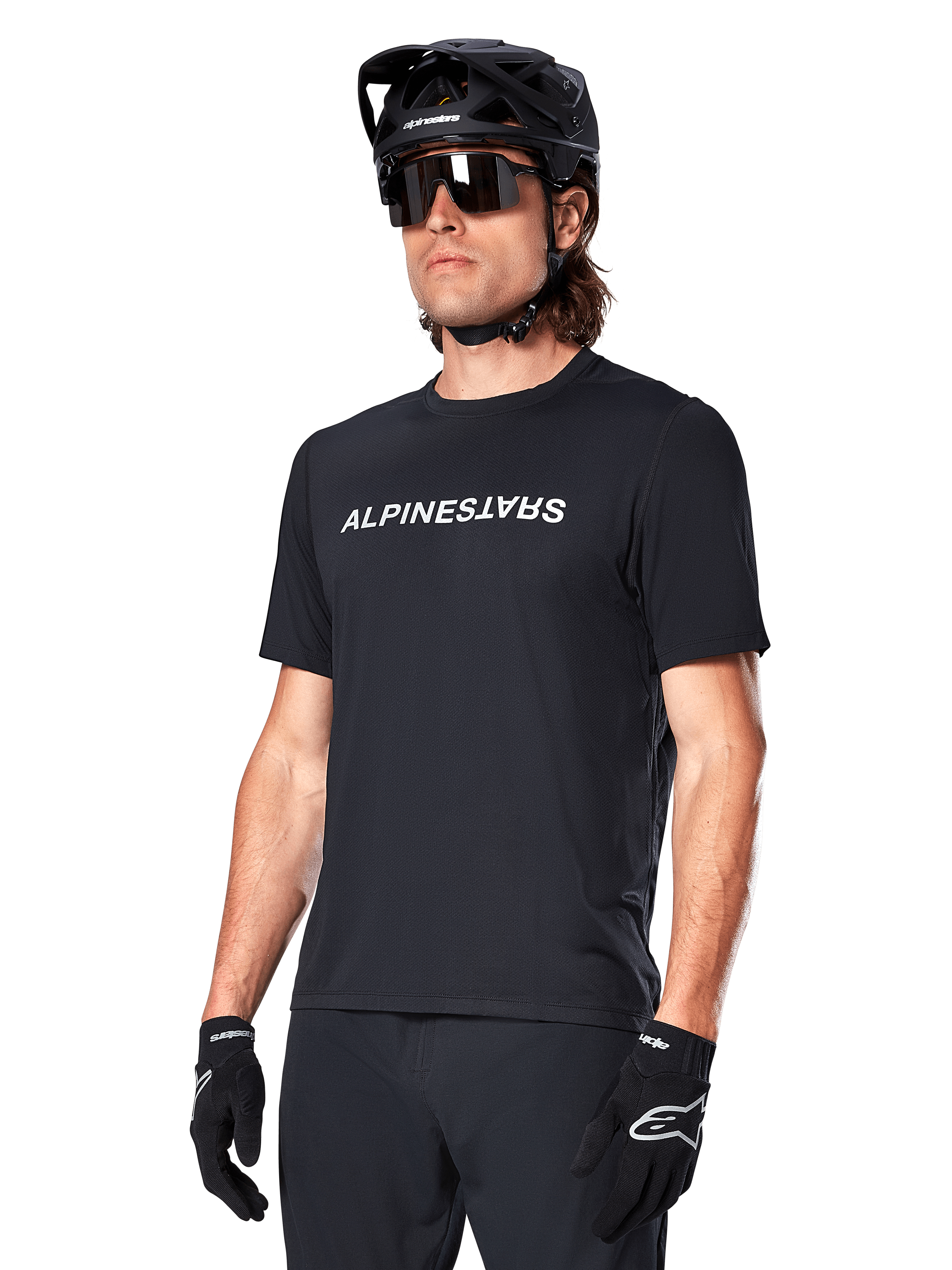 Alpinestars A-Dura Switch Short Sleeve Jersey, Black, featuring a white wordmark logo on the chest, worn by a cyclist with a black MTB helmet and sunglasses, technical apparel designed for trail riding