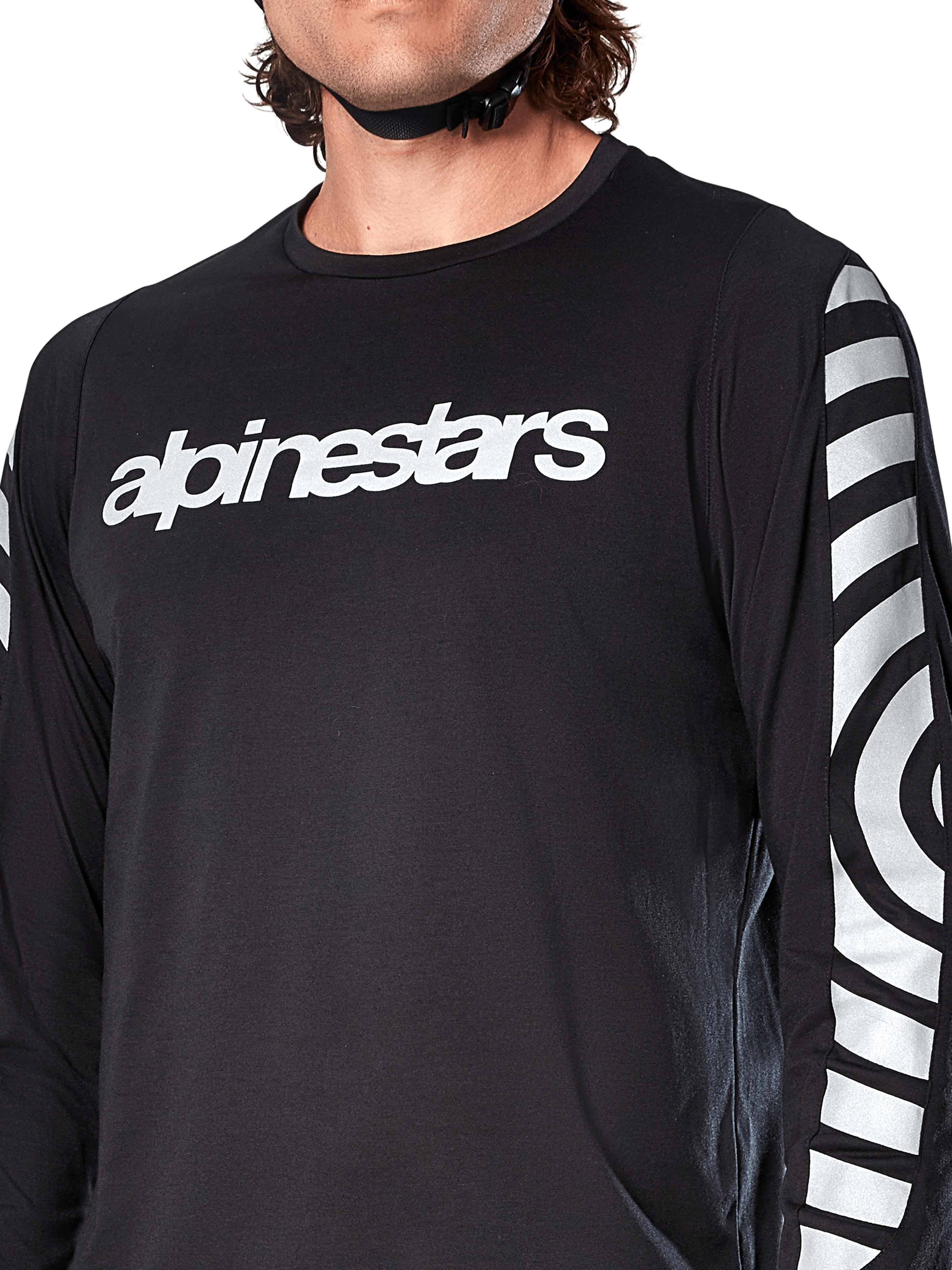 Alpinestars A-Dura Dri Oscar Langarmtrikot, Black Reflective, Nahaufnahme mit weißem Alpinestars-Logo auf der Brust und reflektierenden kreisförmigen Grafiken auf den Ärmeln, technische Radsportbekleidung für Mountainbiking