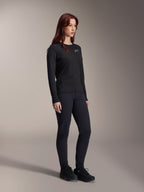Alpinestars Stella A-Dura Thermo-Trikot für Damen, langärmeliges schwarzes MTB-Trikot mit weißem Logo auf der Brust, kombiniert mit passender schwarzer Hose und Sportschuhen, Studioaufnahme für leistungsstarke Fahrradbekleidung