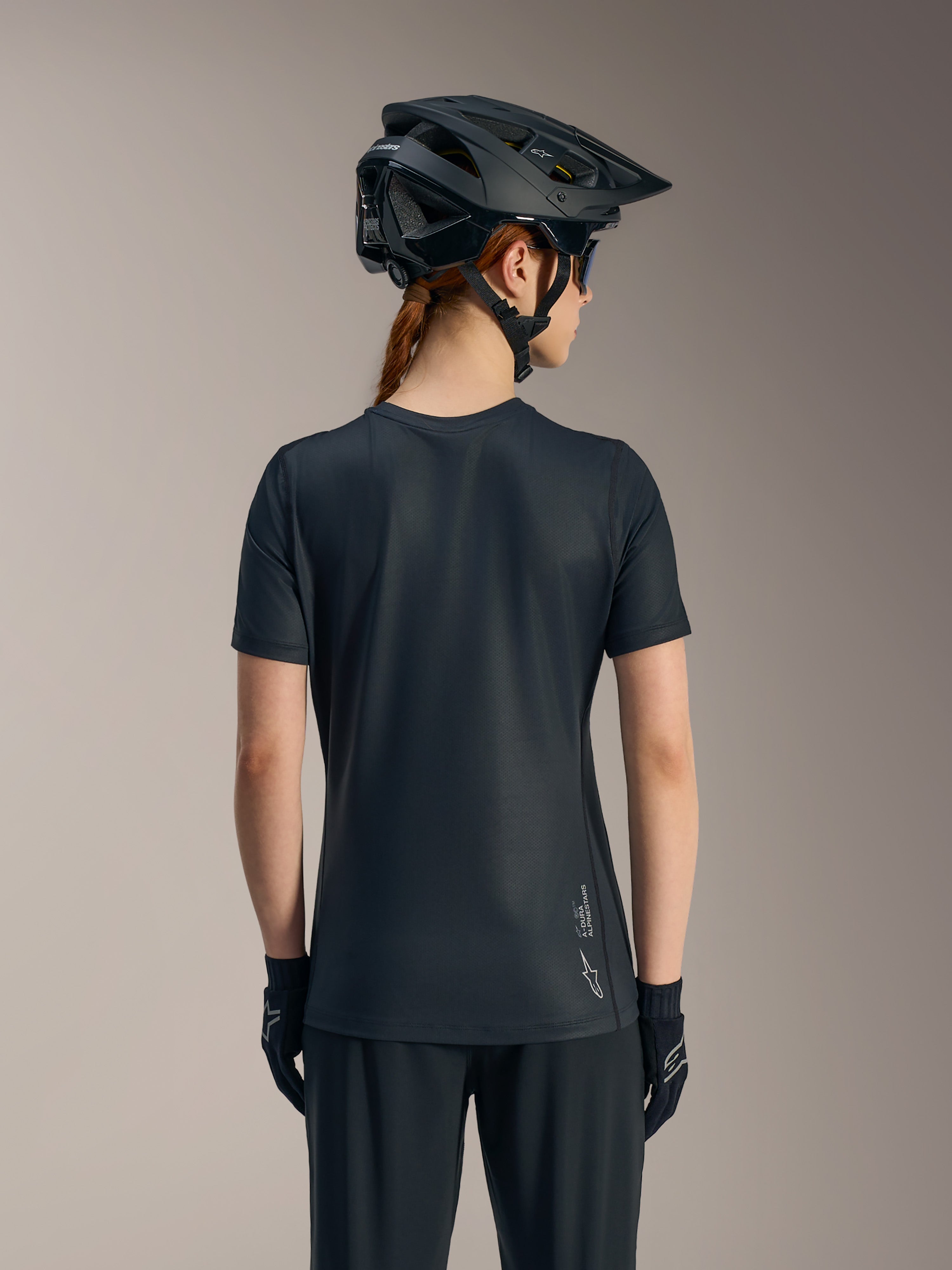 Schwarzes Stella A-Dura Ride Damen-Kurzarmtrikot von hinten, mit verlängertem Saum und Alpinestars-Logo.