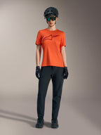 Orange Stella A-Dura Ride Short Sleeve Jersey with a maroon logo, worn with black MTB gear, helmet, and gloves.