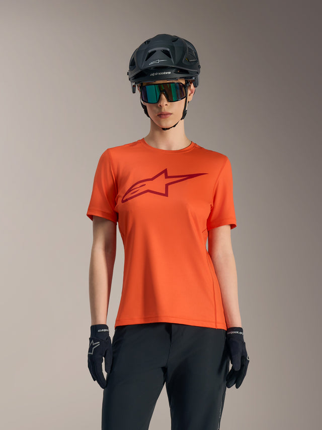 Damen Stella A-Dura Ride Kurzarmtrikot in Orange mit rotem Logo, schwarzem MTB-Helm und Sonnenbrille.