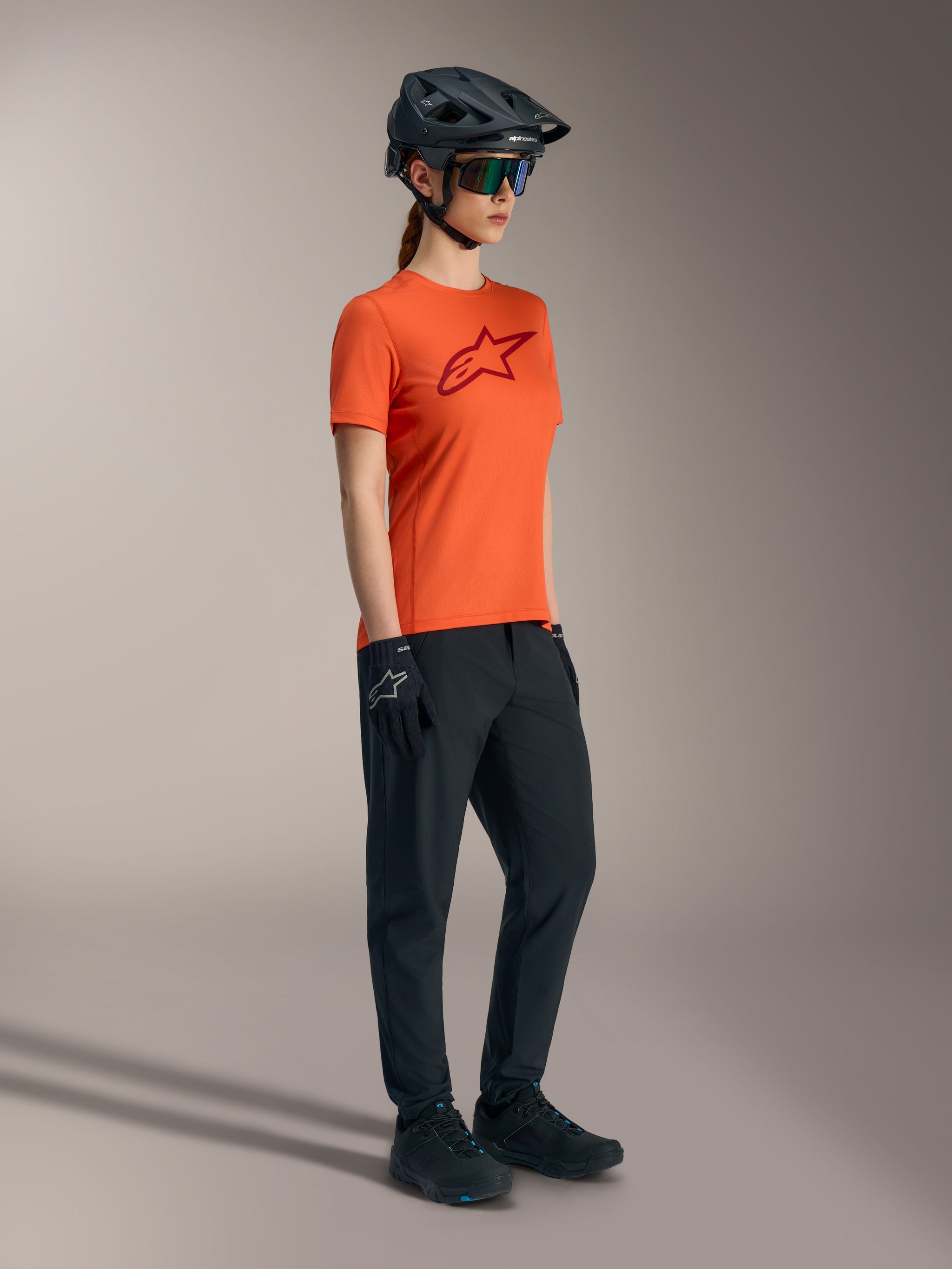 Orange Stella A-Dura Ride Short Sleeve Jersey with red chest logo, technical women's MTB apparel for trail performance.