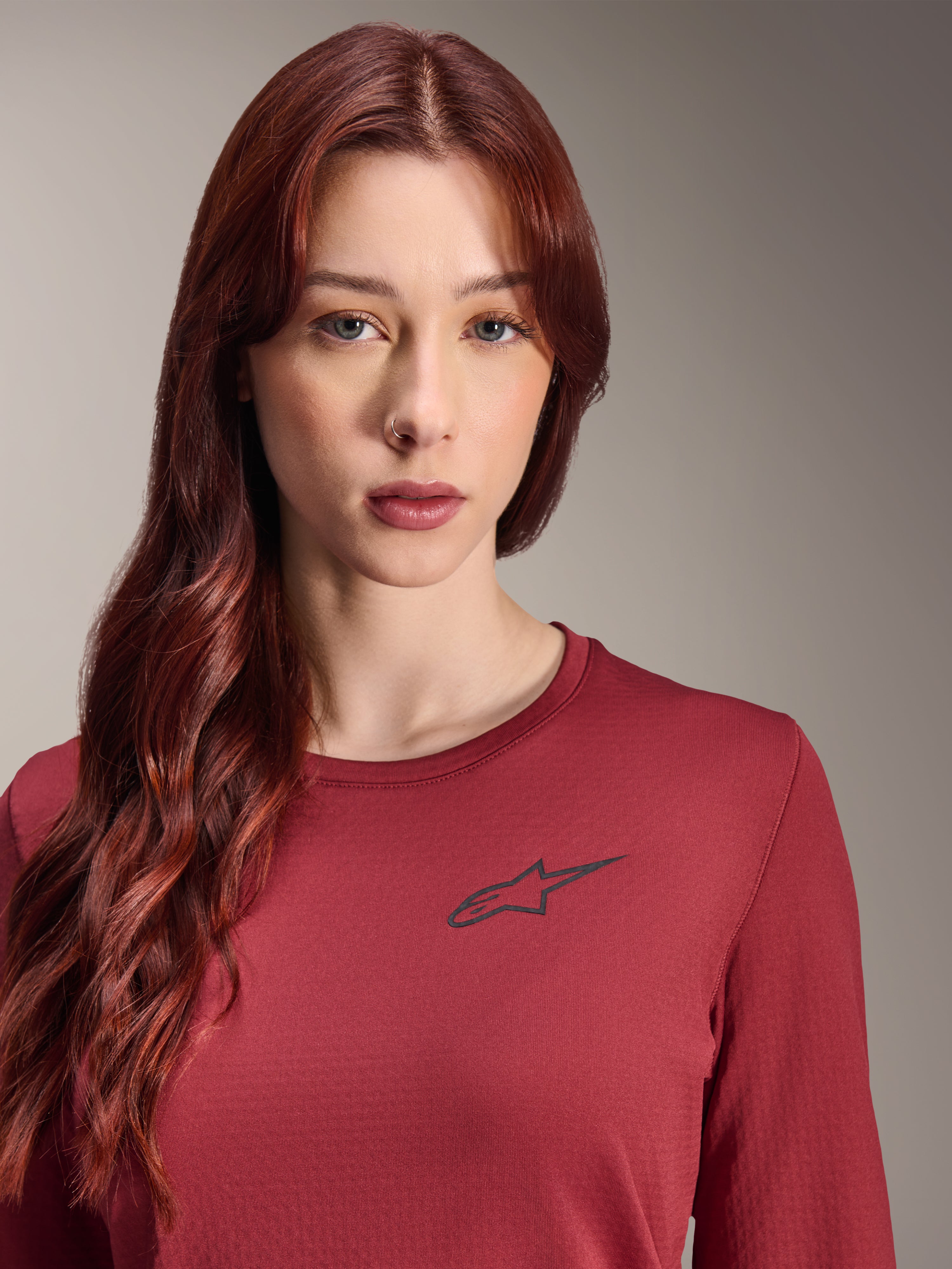 Alpinestars Stella A-Dura Thermo-Trikot, Damen Langarm-MTB-Trikot, Burgund, Nahaufnahme mit schwarzem Stern-Logo auf der Brust, isolierte technische Ausrüstung für Mountainbiking bei kaltem Wetter