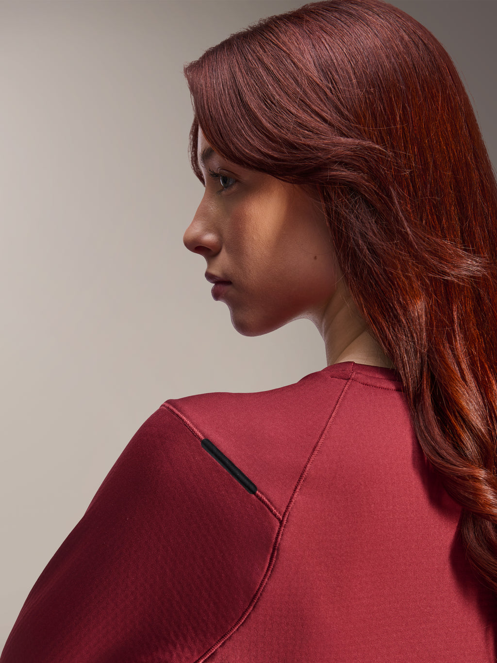Alpinestars Stella A-Dura Thermo-Trikot für Damen, burgunderrotes langärmliges MTB-Trikot, Nahaufnahme im Seitenprofil, Fokus auf Schulternähte und Materialstruktur, Lifestyle-Fahrradausrüstung