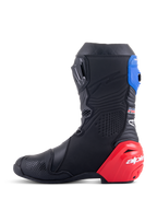 Alpinestars Honda Supertech R Stiefel, Rennmotorradstiefel, Schwarz mit hellroten und blauen Akzenten, mit markantem rotem TPU-Fersenschleifer, blauer oberer Gamasche und Alpinestars-Branding, technisches Design für professionelle Rennstrecken- und Straßenperformance.