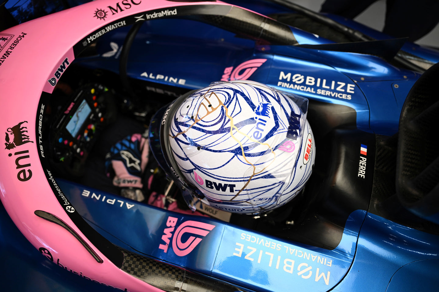 Close-up of a racing helmet inside an Alpine Formula 1 car with visible branding, worn by athlete Pierre Gasly.