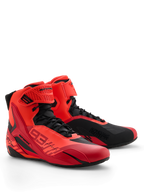 Alpinestars MM93 Faster-4 Schuhe, Motorradschuhe, Red Fluo, Bright Red und Schwarz, Perspektive vorne rechts, mit Marc Marquez 93-Branding, traditioneller Schnürverschluss mit Klettverschlussriemen, sportliches Design mit schützenden TPU-Akzenten und leichter Mikrofaser-Konstruktion.
