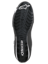 Alpinestars Sektor Schuhe, Motorradschuhe, Schwarz und Weiß, Unteransicht der strukturierten Gummisohle mit wellenförmigem Profilmuster, mit weißem Alpinestars-Logo und Stern-Symbol.