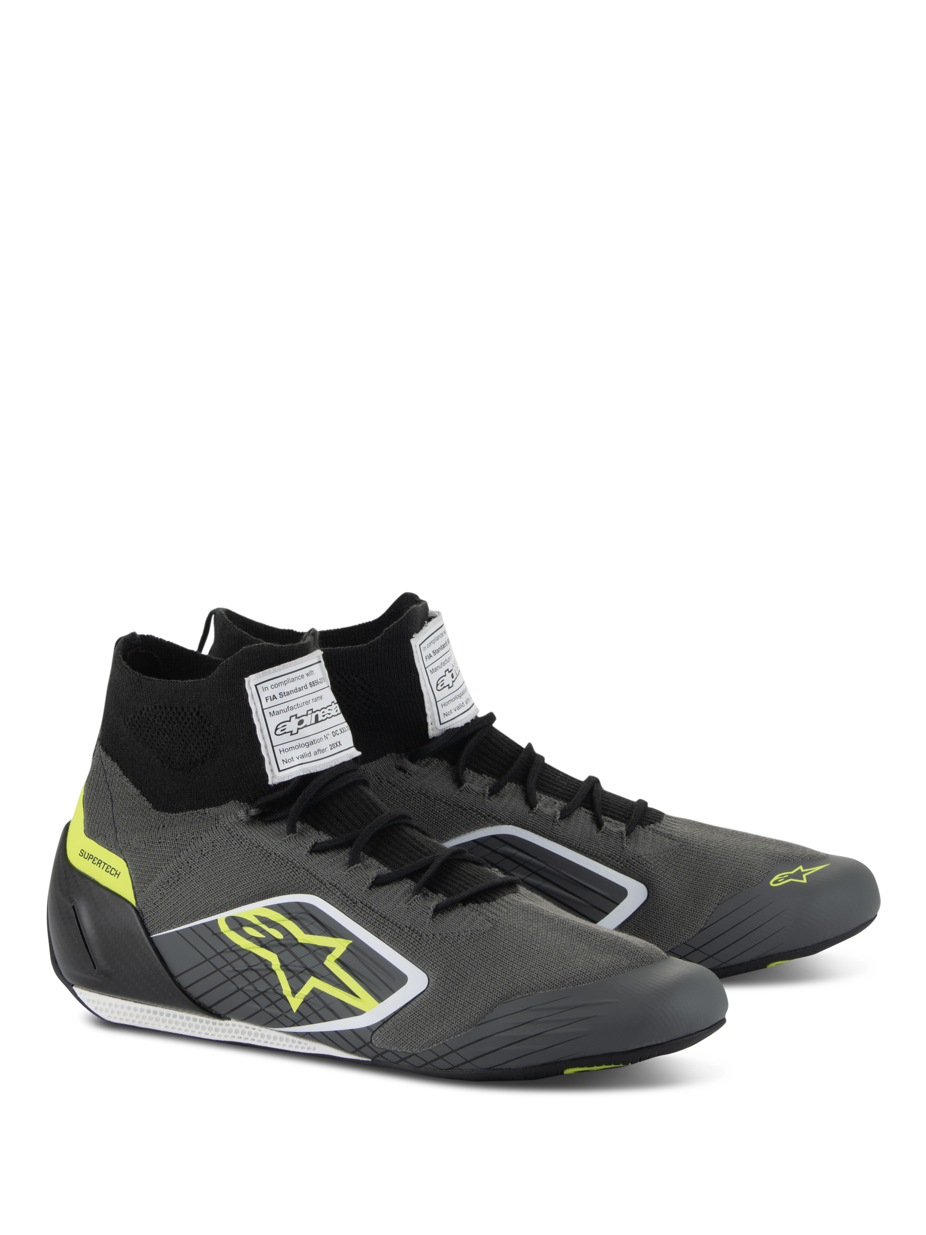 Alpinestars Supertech Shoes, Auto Racing Footwear, Cool Gray and Black with Fluo Yellow accents, featuring a knitted aramidic upper, carbon fiber heel cup, and white FIA certification labels on the tongue, professional motorsport design
