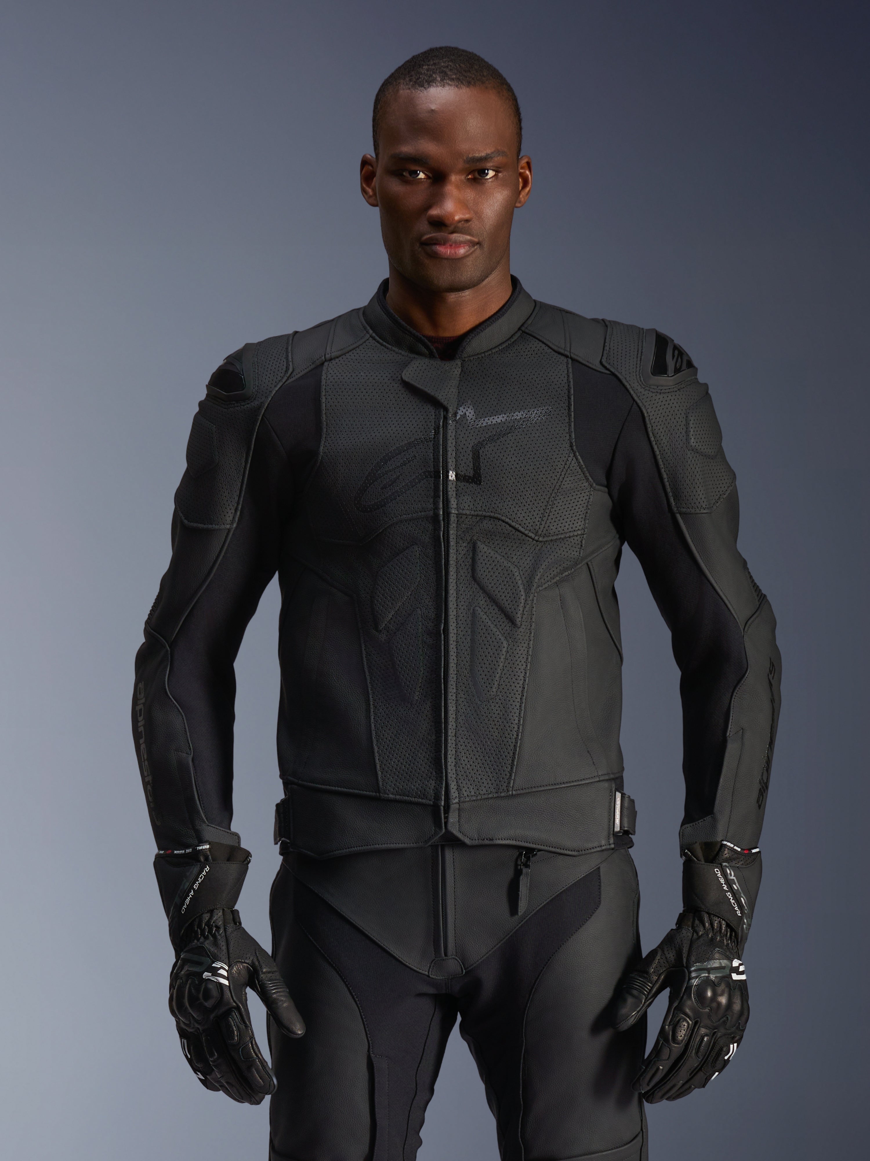 Alpinestars Dusk Airflow Lederjacke, schwarze Motorradjacke, perforiertes Leder mit Schutzpolsterung an den Schultern, körperbetontes Design, getragen mit passenden schwarzen gepanzerten Handschuhen