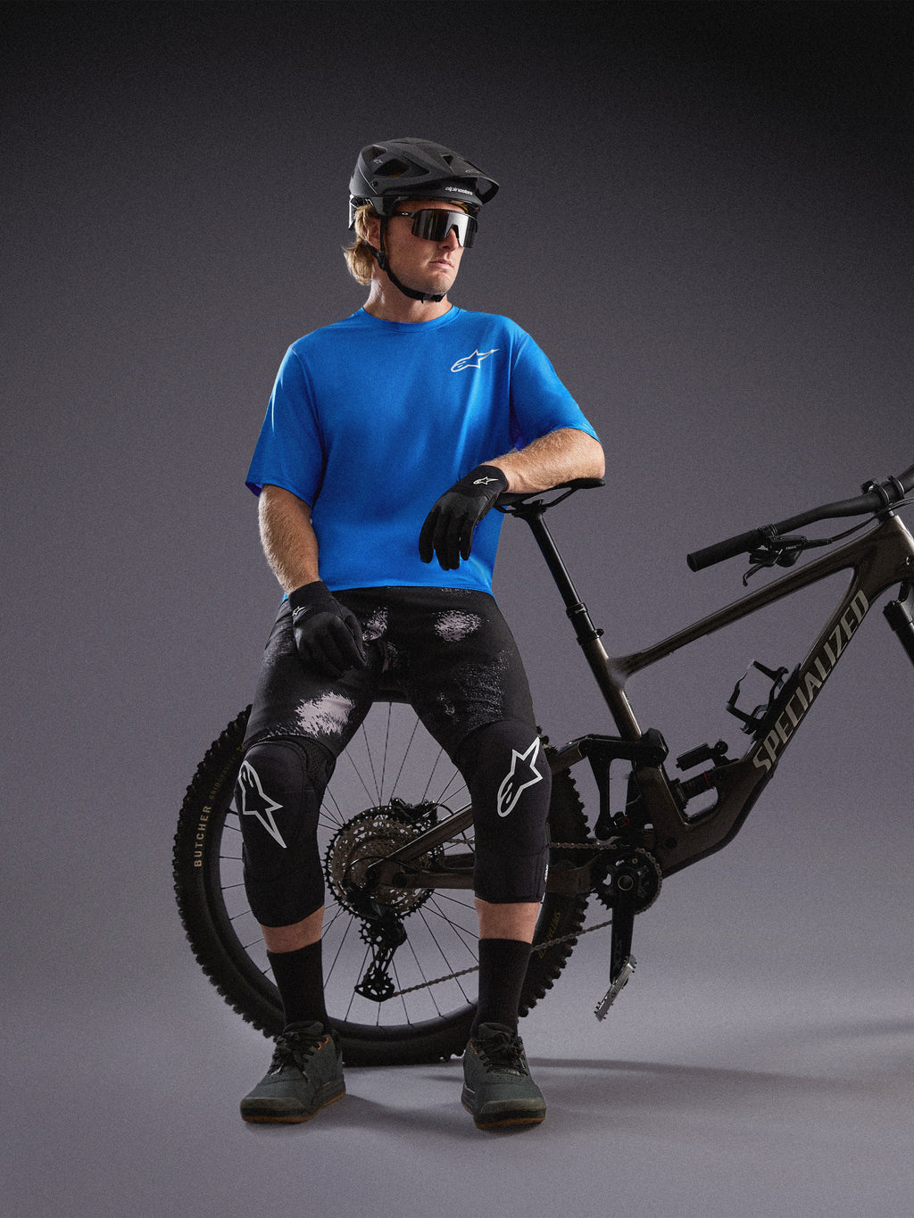 Alpinestars A-Dura Air SS Jersey und Black Camo Ride Shorts, getragen von einem Radfahrer mit Mountainbike im Studio.