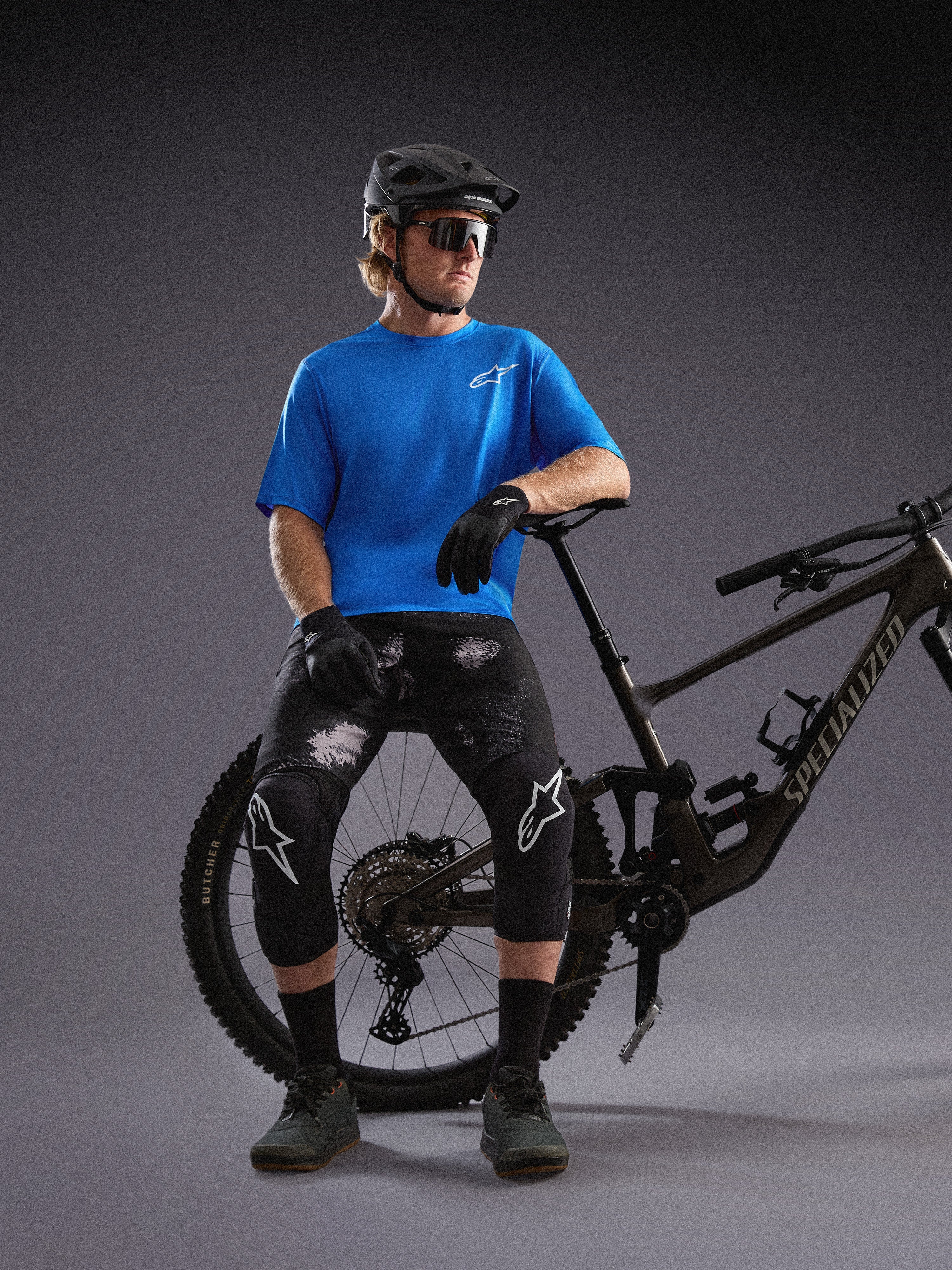 Alpinestars A-Dura Air SS Jersey und Black Camo Ride Shorts, getragen von einem Radfahrer mit Mountainbike im Studio.
