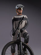 Gray Alpinestars A-Dura Race Long Sleeve Jersey on an MTB rider, featuring black accents and professional cycling gear.