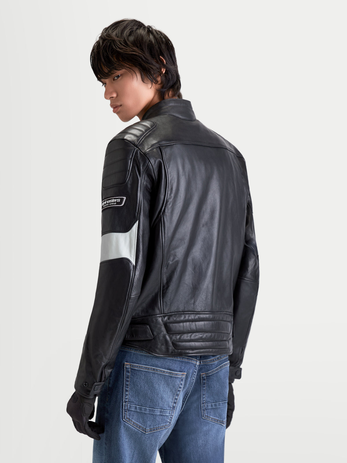 Alpinestars Revern Lederjacke, urbane Motorrad-Lederjacke für Herren in Schwarz und Metallgrau, Rückansicht an einem Model mit Jeans, mit genarbtem Rindsleder und Heritage-Design