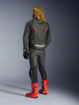 Alpinestars GP Force V2 Lederjacke, Schwarz-Rot-Fluo, Rückansicht getragen von einem Fahrer mit passender schwarzer Lederhose, roten Rennstiefeln und schwarzen Handschuhen, mit markanten roten Akzenten und Alpinestars-Branding auf dem Rücken, Motorradausrüstung in Sport-Passform