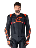 Alpinestars Missile V3 Ignition Lederjacke, Motorrad-Rennjacke, Schwarz und Fluo-Rot, getragen mit passenden Rennhandschuhen und Lederhose, mit perforierter Belüftung und markantem Alpinestars-Branding, professionelle Rennausrüstung
