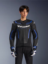Alpinestars GP Force V2 Airflow Lederjacke, Schwarz Metallic Blau, Motorradjacke mit perforiertem Leder und blauen Akzenten, getragen von einem Model mit passenden Rennhandschuhen und schwarzer Hose, professionelle Sport-Fahrerausrüstung