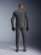 Männliches Model in der Rückansicht mit der Alpinestars Dusk Airflow Lederjacke in Schwarz, kombiniert mit passender schwarzer Leder-Rennhose, Handschuhen und Stiefeln, mit großflächigen Perforationen zur Belüftung und dem Alpinestars-Logo auf dem unteren Rücken.