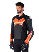 Alpinestars Faster V3 Lederjacke, Schwarz und Fluo-Rot, Premium-Sport-Motorradjacke mit weißen und roten Akzenten, Alpinestars-Branding auf Brust und Ärmeln, getragen mit schwarzen Motorradhandschuhen und Hosen.