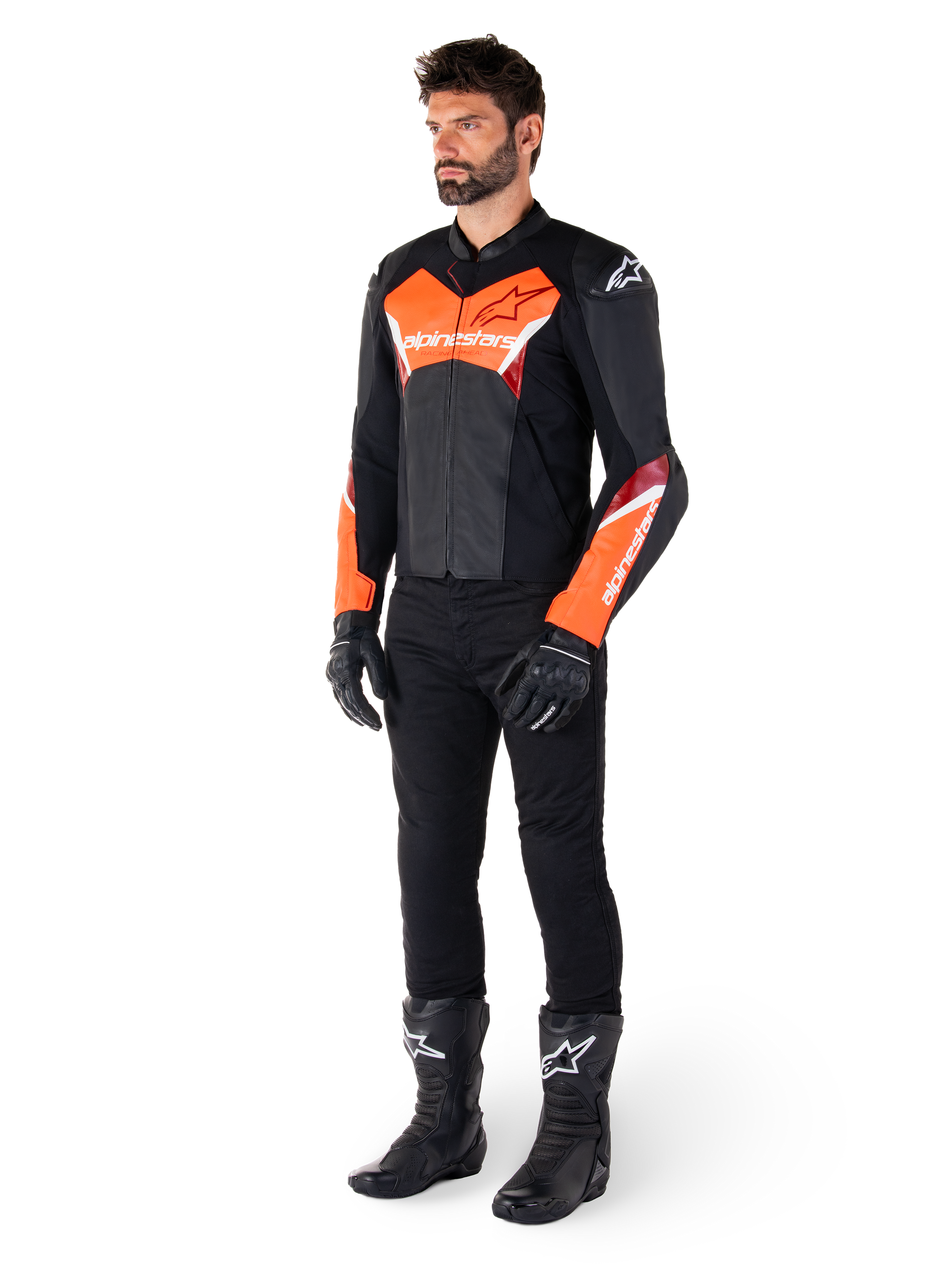 Männlicher Fahrer in der Alpinestars Faster V3 Lederjacke in Schwarz und Rot Fluo, kombiniert mit schwarzer Motorradhose, Handschuhen und Stiefeln. Die Jacke zeichnet sich durch eine vom Rennsport abgeleitete Silhouette mit markanten fluoreszierenden roten Akzenten an Brust und Ärmeln, weißem Alpinestars-Branding und einer hochwertigen Lederkonstruktion aus.