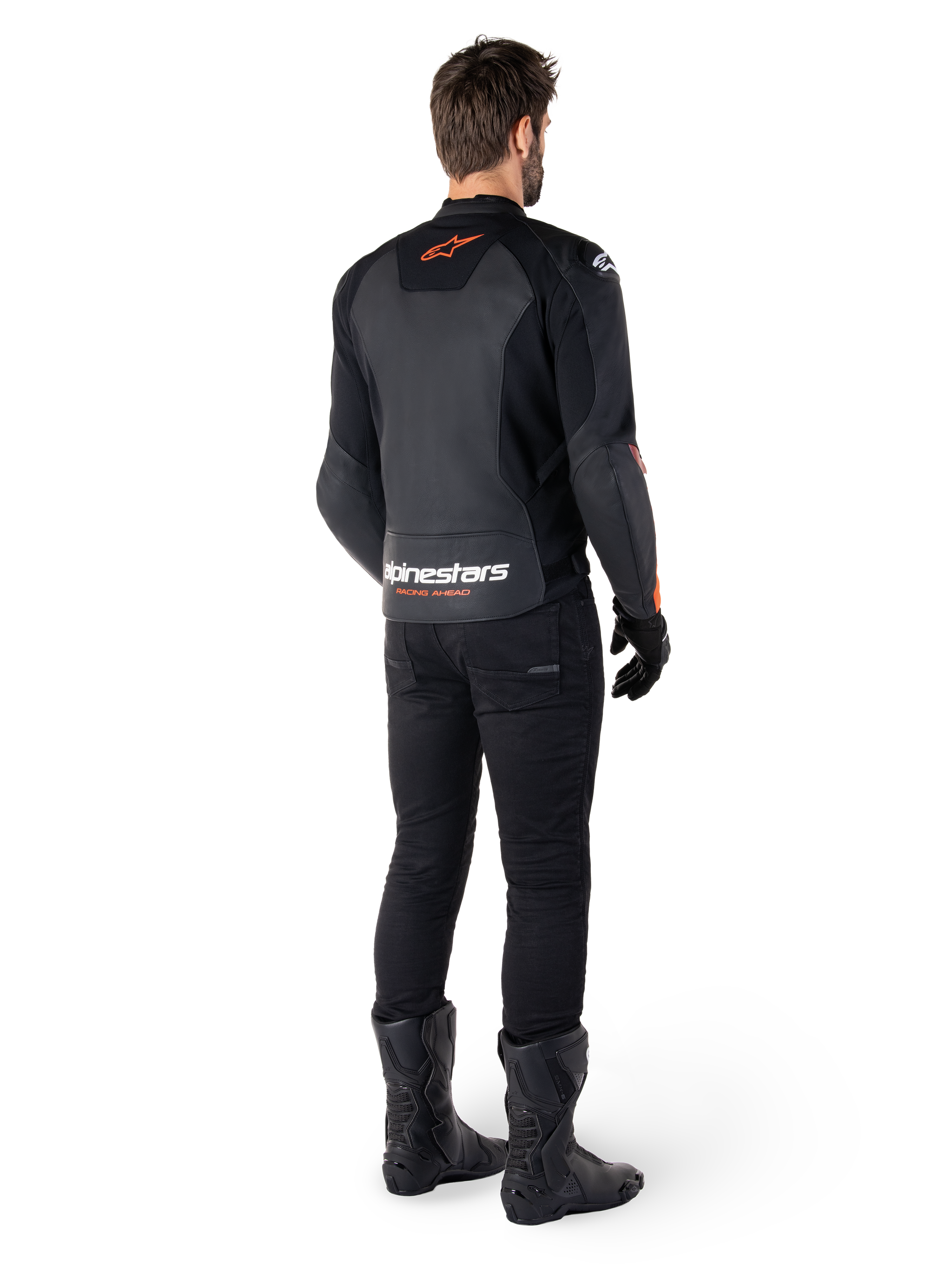 Alpinestars Faster V3 Lederjacke, Sport-Motorradjacke, Schwarz und Rot Fluo, Rückansicht getragen mit schwarzer Hose und schwarzen Stiefeln, mit „alpinestars RACING AHEAD“-Schriftzug am unteren Rücken und einem kleinen roten Stern-Logo, schlanke Lederkonstruktion in sportlicher Passform