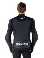 Alpinestars Faster V3 Lederjacke, Sport-Motorradjacke, Schwarz mit weißem Branding, Rückansicht von einem Model getragen, mit dem Alpinestars-Logo auf dem oberen Rücken und dem Schriftzug „RACING AHEAD“ auf dem unteren Rücken, hochwertige Lederkonstruktion mit ergonomischen Stretch-Einsätzen.