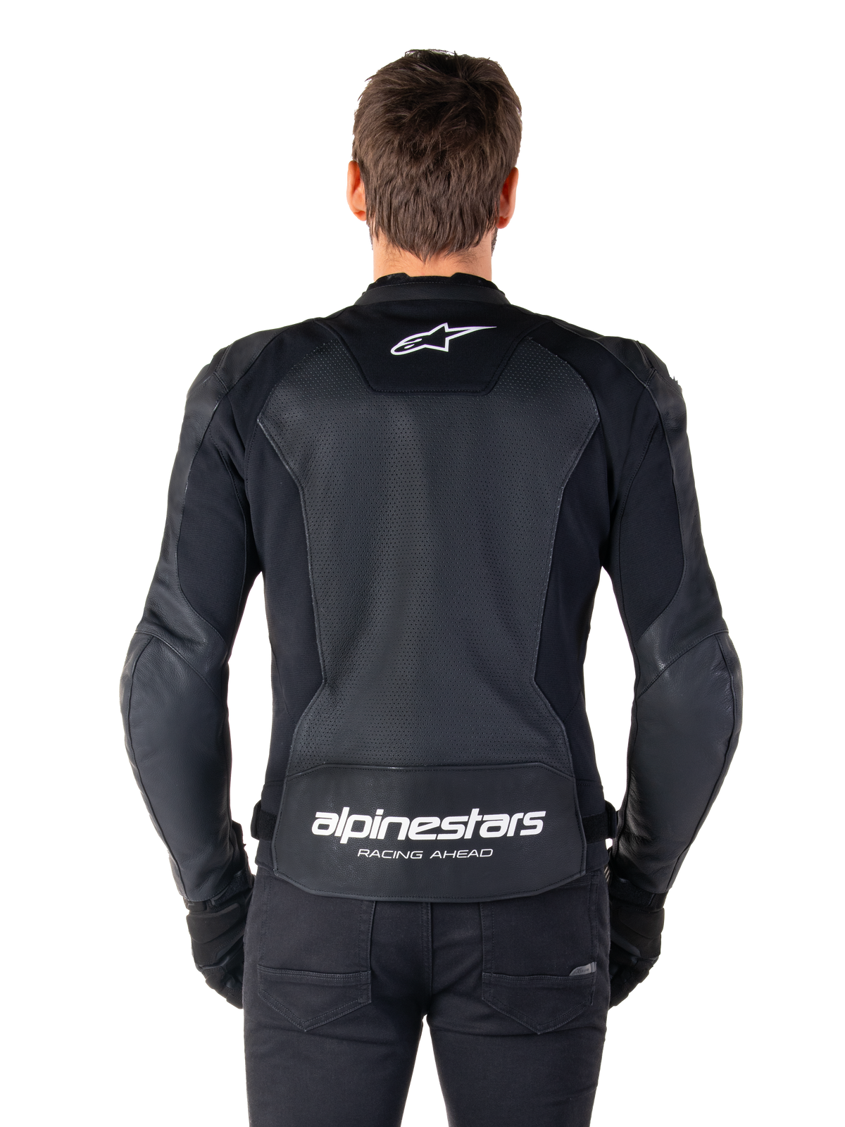 Alpinestars Faster V3 Airflow Leather Jacket, Black and White, rear view of a rider showing the perforated leather back panel for ventilation, white Alpinestars logo on upper back and 'RACING AHEAD' branding on lower back, sport-fit motorcycle gear.