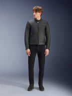 Alpinestars Dyno Lederjacke, Schwarz, getragen von einem männlichen Model mit schwarzer Hose und schwarzen Stiefeln, Premium-Leder-Motorradjacke mit minimalistischem Heritage-Design, Ganzkörperansicht im Stehen