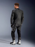 Alpinestars Caliber Lederjacke, schwarze Motorradjacke, Rückansicht, mit perforiertem Leder und Akkordeon-Stretcheinsätzen an Taille und Schultern, geprägtes Logo, getragen mit schwarzer Lederhose und weißen Rennstiefeln