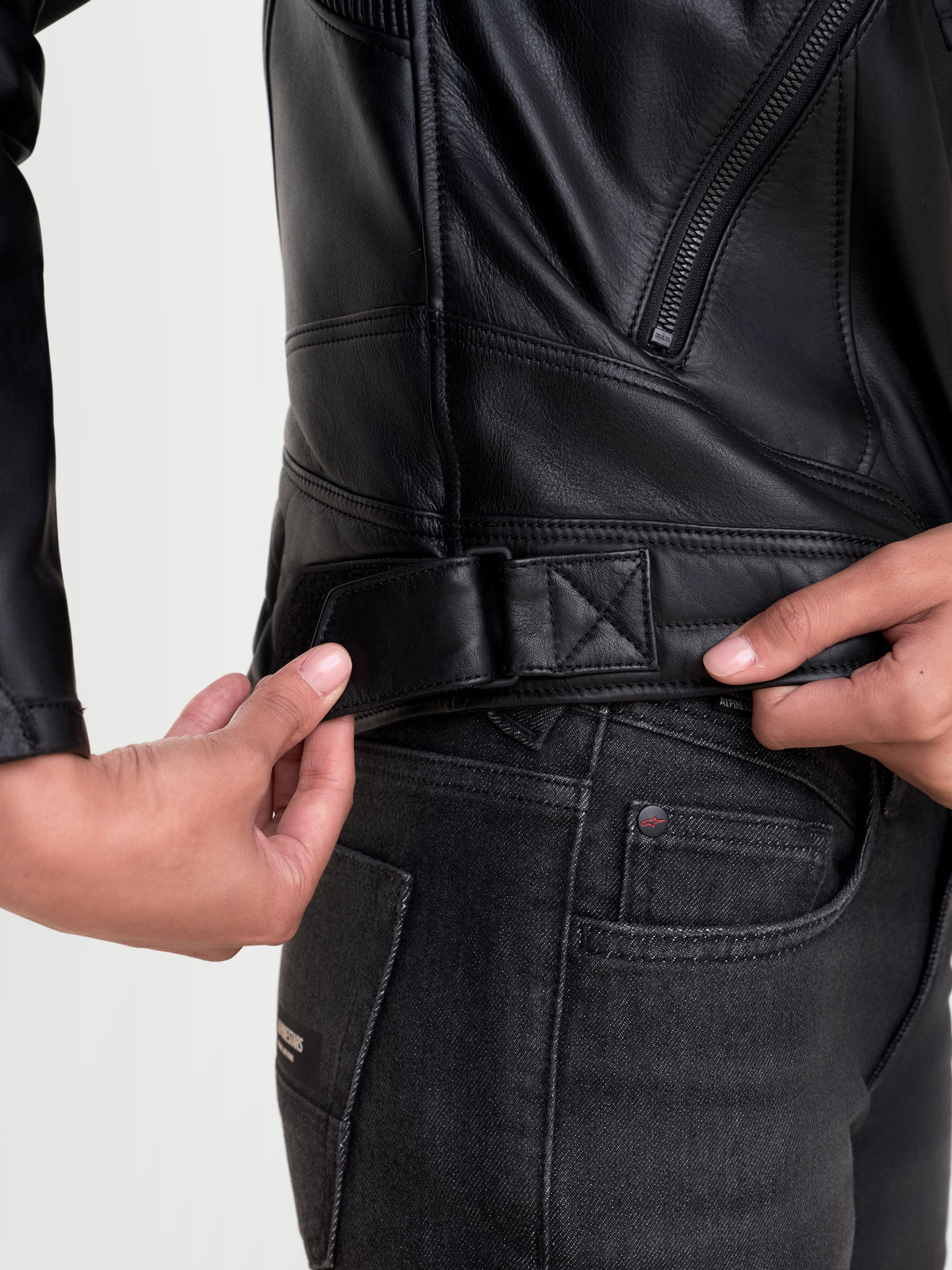 Alpinestars Revea Damen Lederjacke, urbane Motorradjacke in Schwarz, Nahaufnahme der Taillenverstellung und der Konstruktion aus vollnarbigem Rindsleder an einem Model