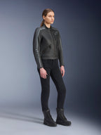 Alpinestars Stella Dyno Lederjacke, Damen-Motorradjacke, Schwarz, Tar Gray und Dunkelgrau, getragen mit schwarzer Motorradhose und Stiefeln, mit grauen Rennstreifen an den Ärmeln und Heritage-Lederdesign